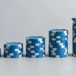 Pokerimerkkejä kannettavan tietokoneen vierellä pörssikäyrän edessä, kuvitus odotusarvoajattelusta sijoittamisessa.