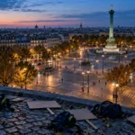 Stradă din Paris la căderea serii, cu o cafenea și un magazin cu vitrinele sparte, acoperite cu scânduri după violențe