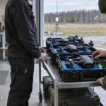 Insenerid jälgivad õhus hõljuvat drooni maapealse juhtimisjaama kõrval Eesti rannikumaastikul